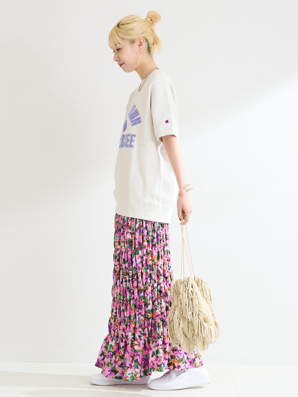 ホワイト系のスウェット、パープル系のスカートを着用したレディースの春コーディネートの2枚目の写真