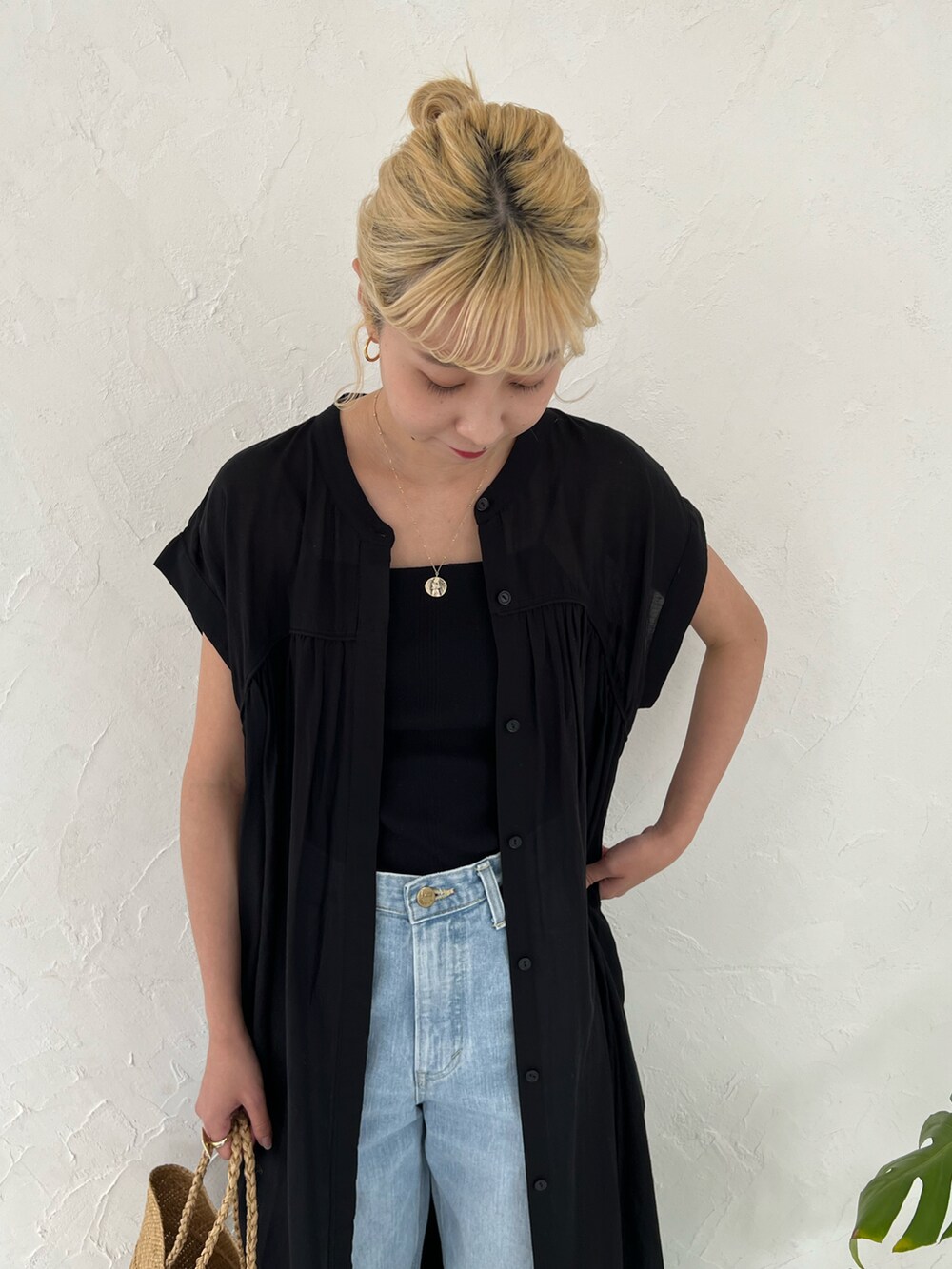 ブラック系のワンピース、ブルー系のデニムパンツを着用したレディースの春コーディネートの5枚目の写真