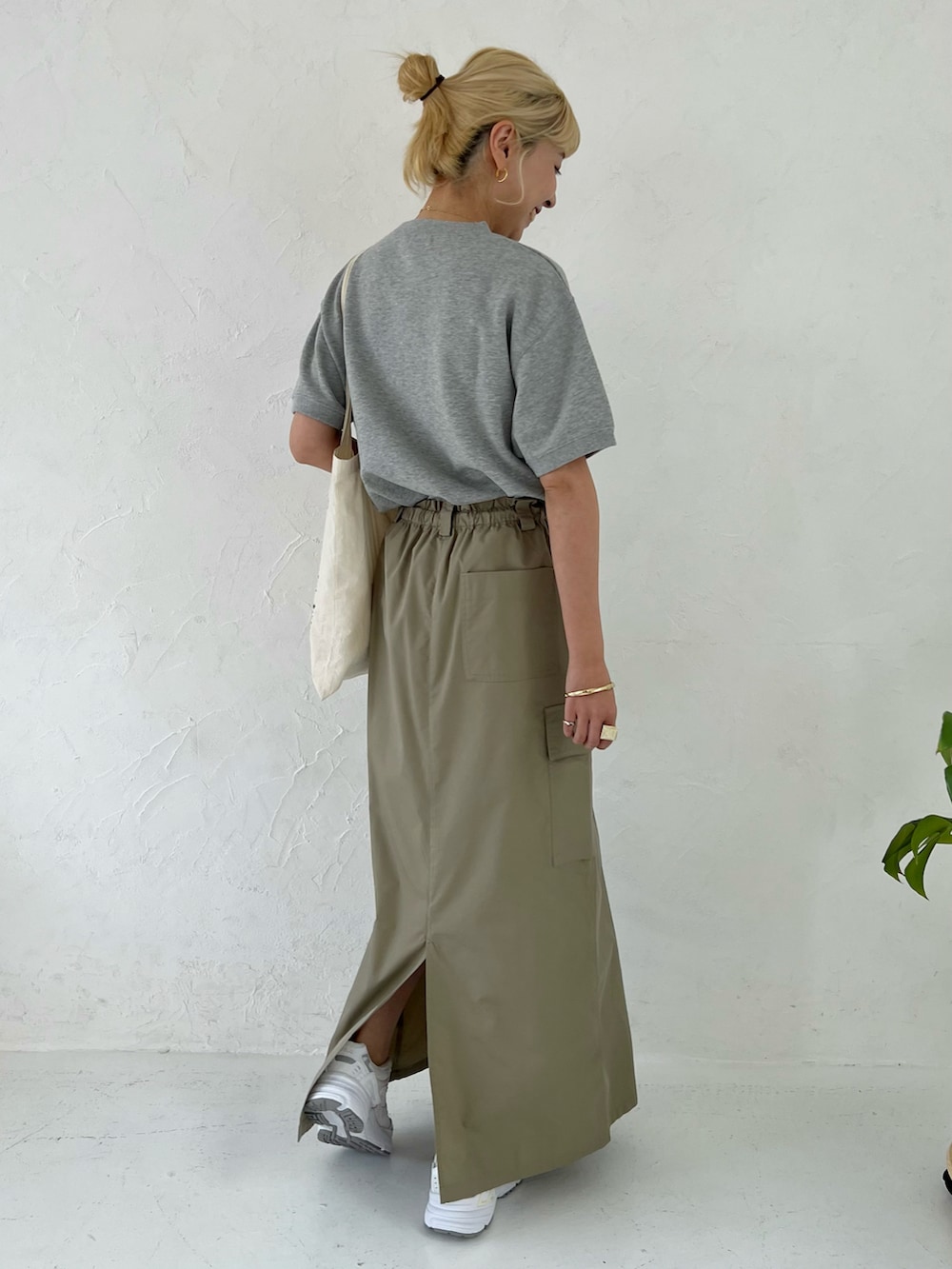 グレー系のスウェット、グリーン系のスカートを着用したレディースの春コーディネートの3枚目の写真