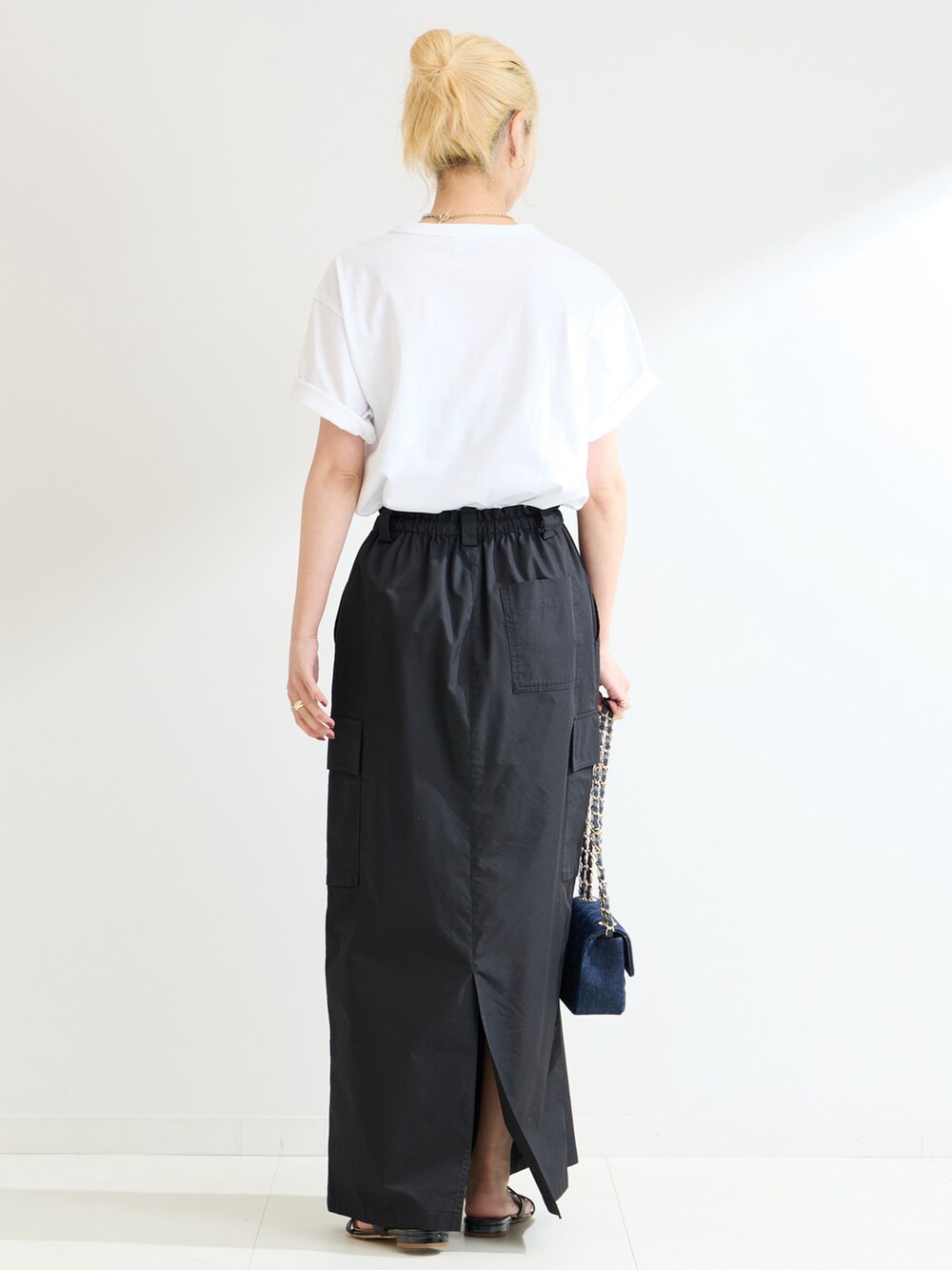 ブラック系のスカート、ホワイト系のTシャツ/カットソーを着用したレディースの春コーディネートの3枚目の写真