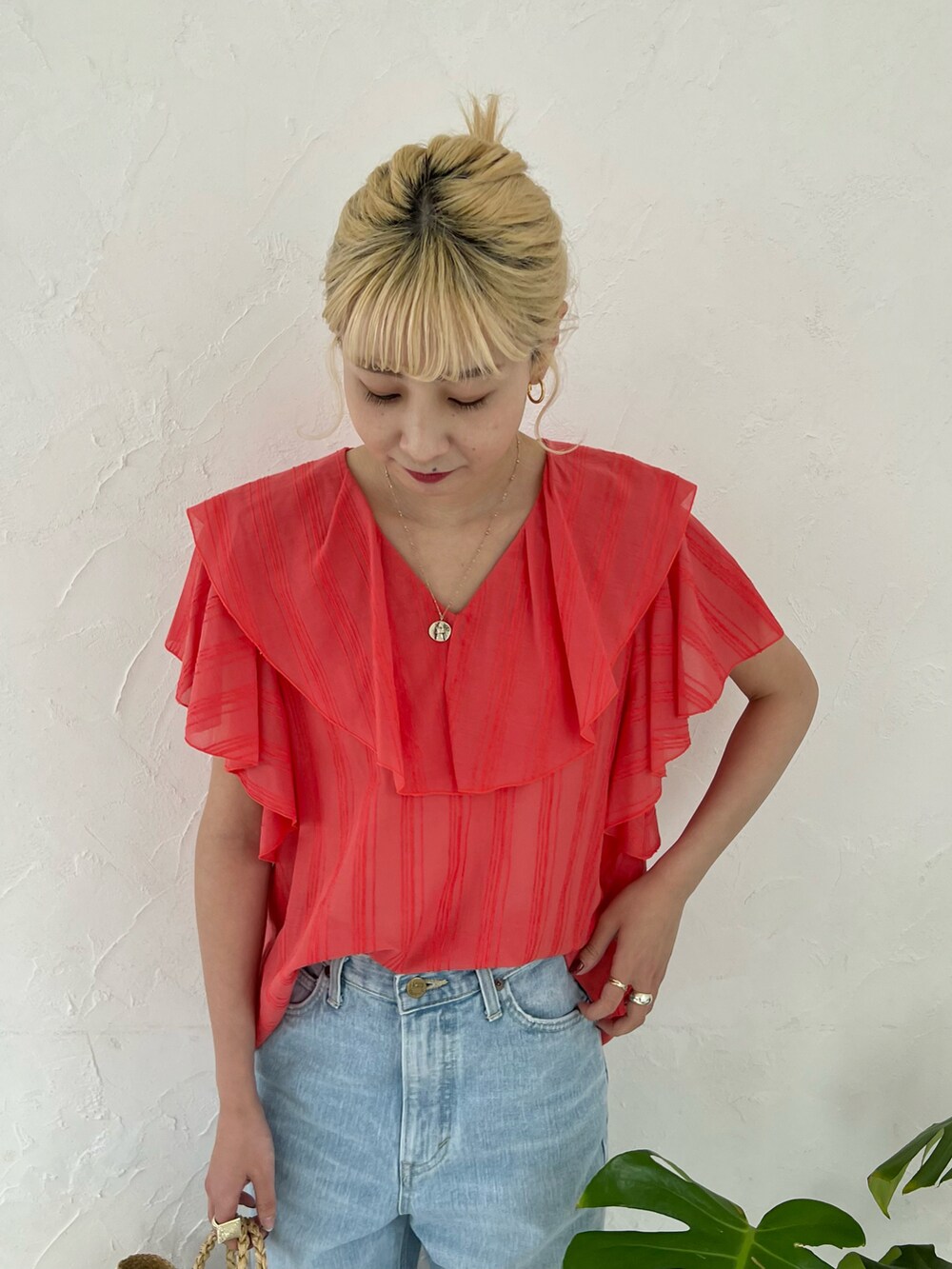 オレンジ系のシャツ/ブラウス、ブルー系のデニムパンツを着用したレディースの春コーディネートの3枚目の写真