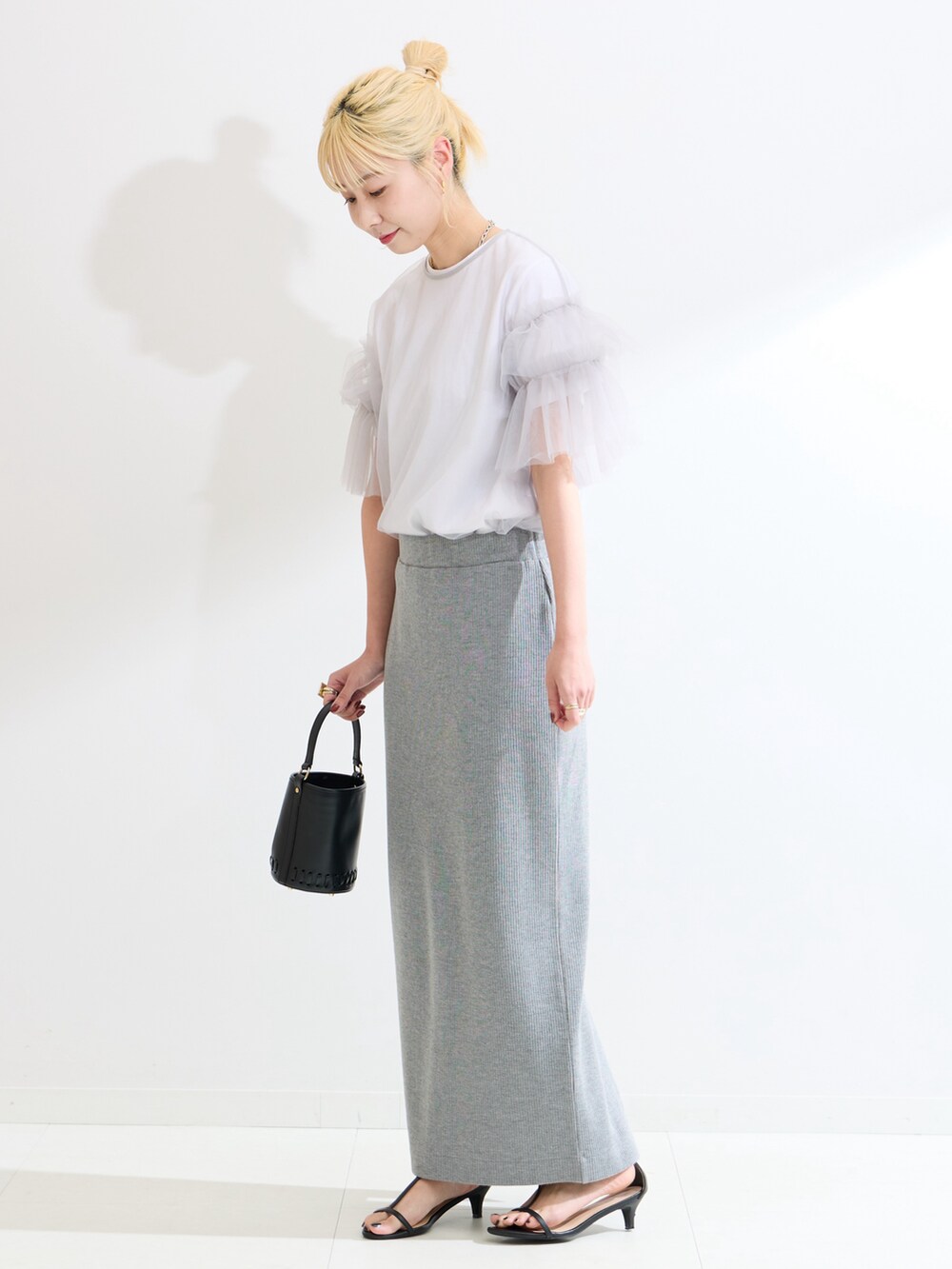 グレー系のTシャツ/カットソー、グレー系のスカートを着用したレディースの春コーディネートの2枚目の写真