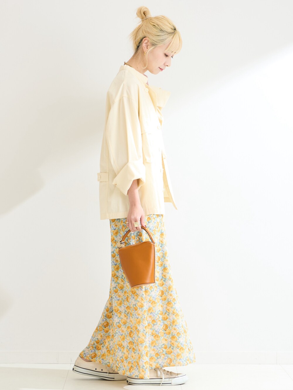 イエロー系のワンピース、ホワイト系のシャツ/ブラウスを着用したレディースの春コーディネートの2枚目の写真