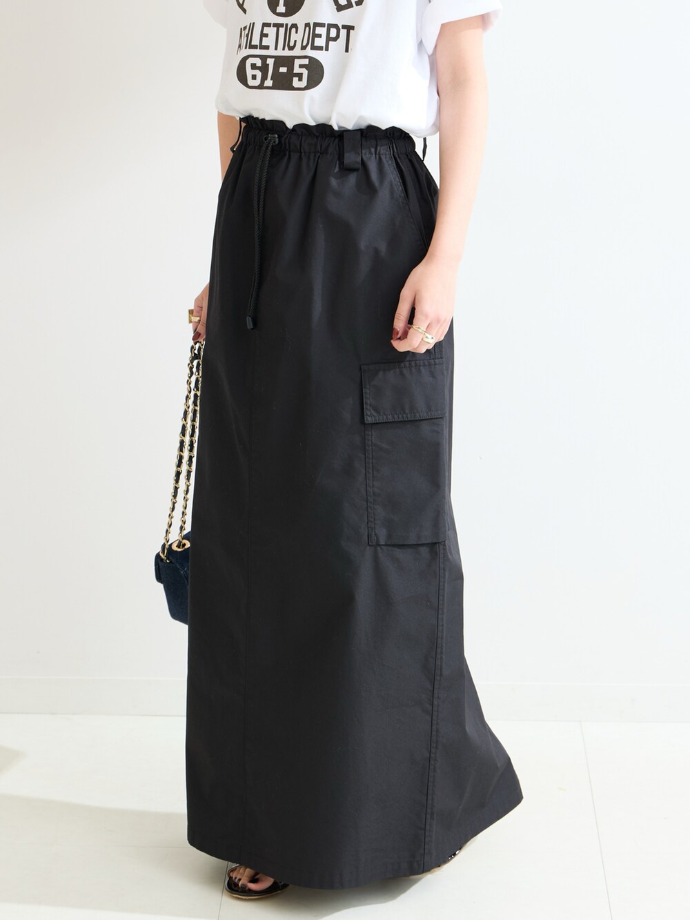 ブラック系のスカート、ホワイト系のTシャツ/カットソーを着用したレディースの春コーディネートの5枚目の写真