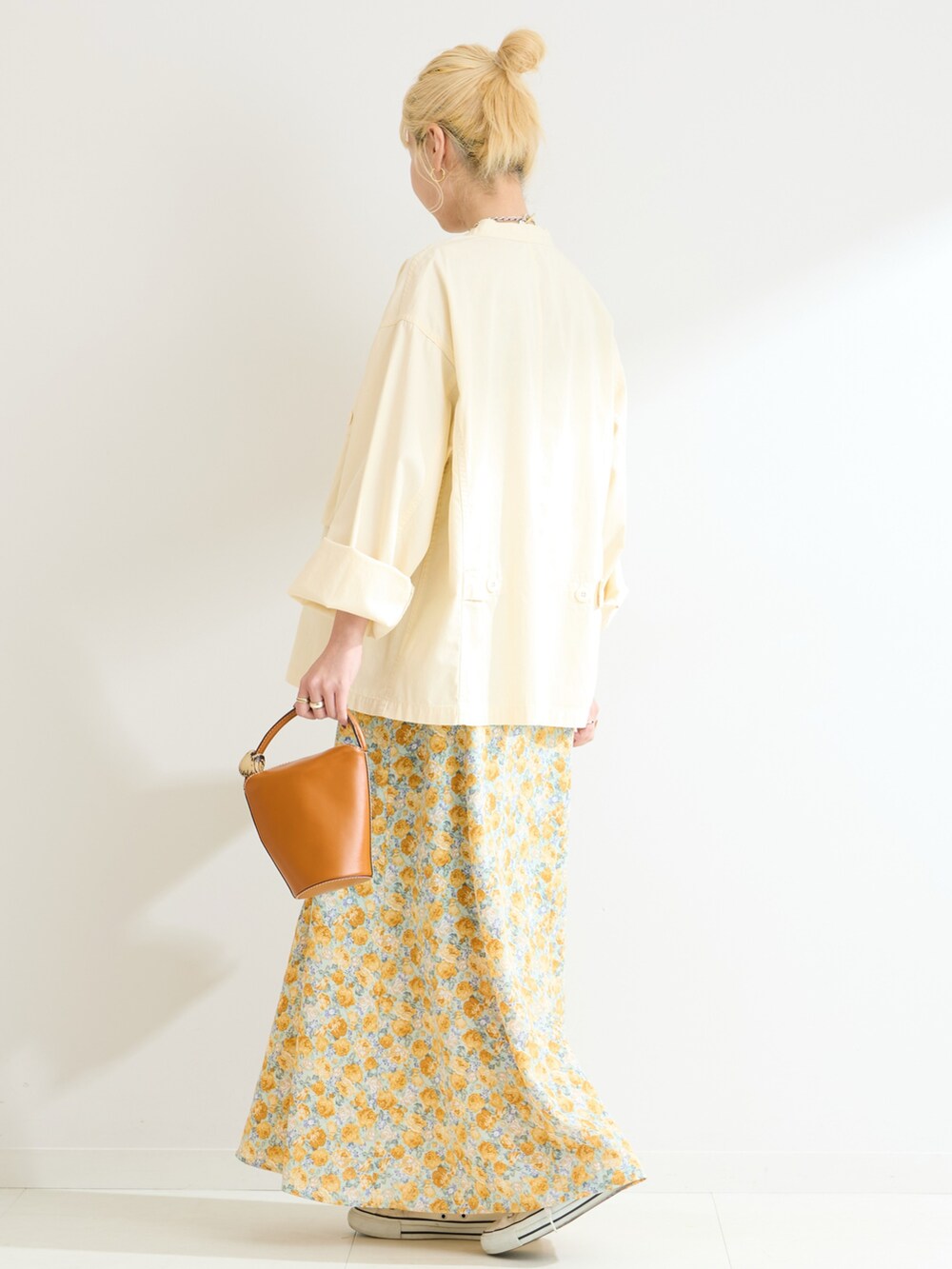 イエロー系のワンピース、ホワイト系のシャツ/ブラウスを着用したレディースの春コーディネートの3枚目の写真