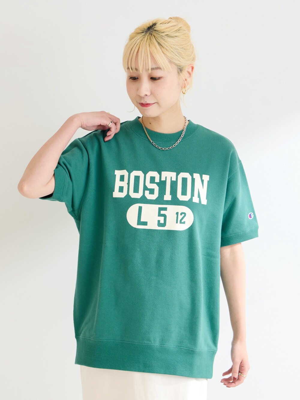 グリーン系のスウェット、ホワイト系のスカートを着用したレディースの春コーディネートの4枚目の写真