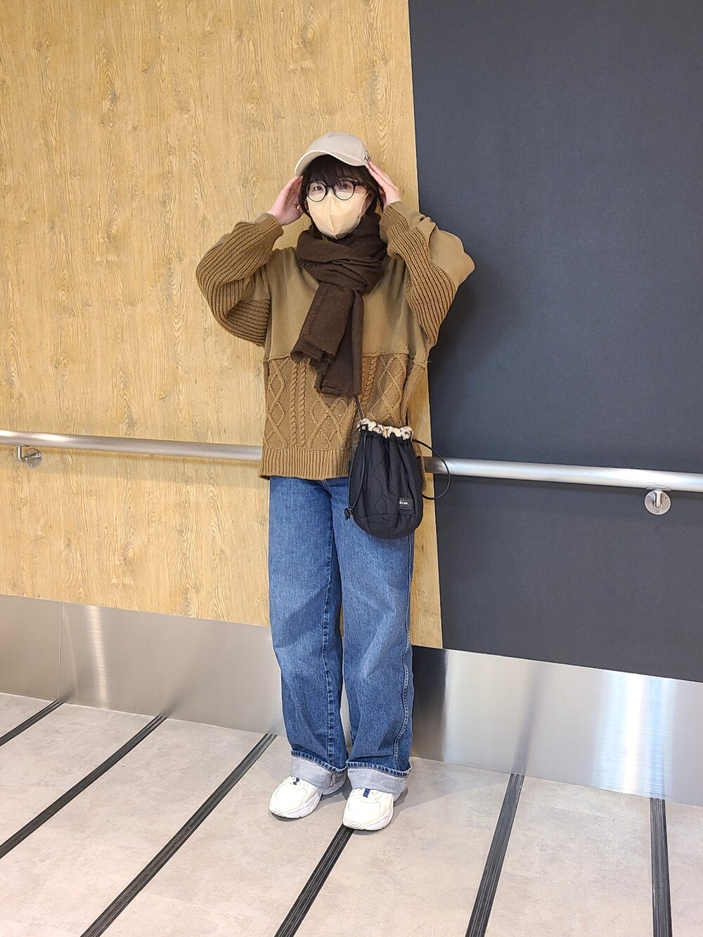 ブルー系のデニムパンツ、その他のショルダーバッグ、ブラウン系のニット/セーターを着用したレディースの冬コーディネートの3枚目の写真