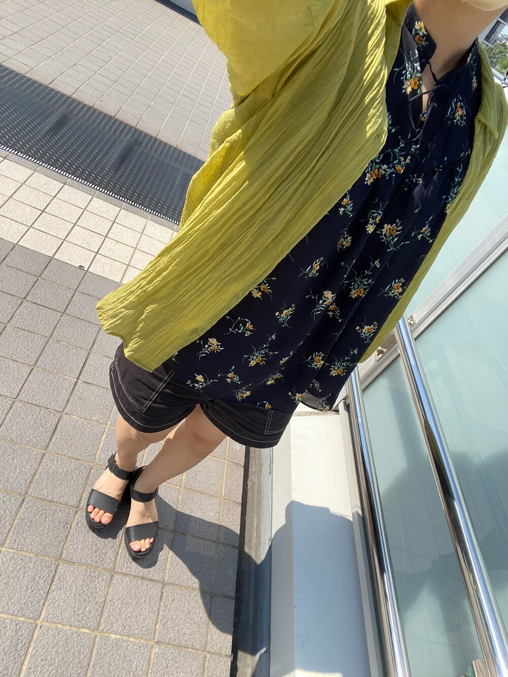 ブラック系のパンツ、グリーン系のシャツ/ブラウス、ブラック系のサンダルを着用したレディースの夏コーディネートの2枚目の写真