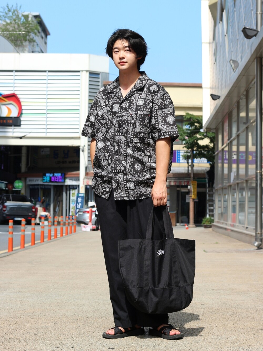 ブラック系のトートバッグ、ブラック系のシャツ/ブラウスを着用したメンズの夏コーディネートの3枚目の写真