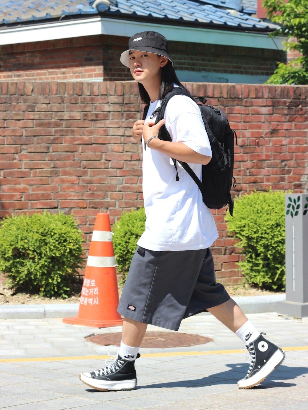 ホワイト系のTシャツ/カットソー、グレー系のデニムパンツ、ブラック系のスニーカーを着用したメンズの春コーディネートの2枚目の写真