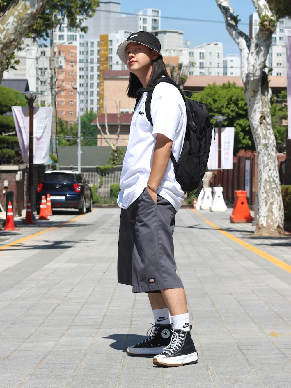 ホワイト系のTシャツ/カットソー、グレー系のデニムパンツ、ブラック系のスニーカーを着用したメンズの春コーディネートの3枚目の写真