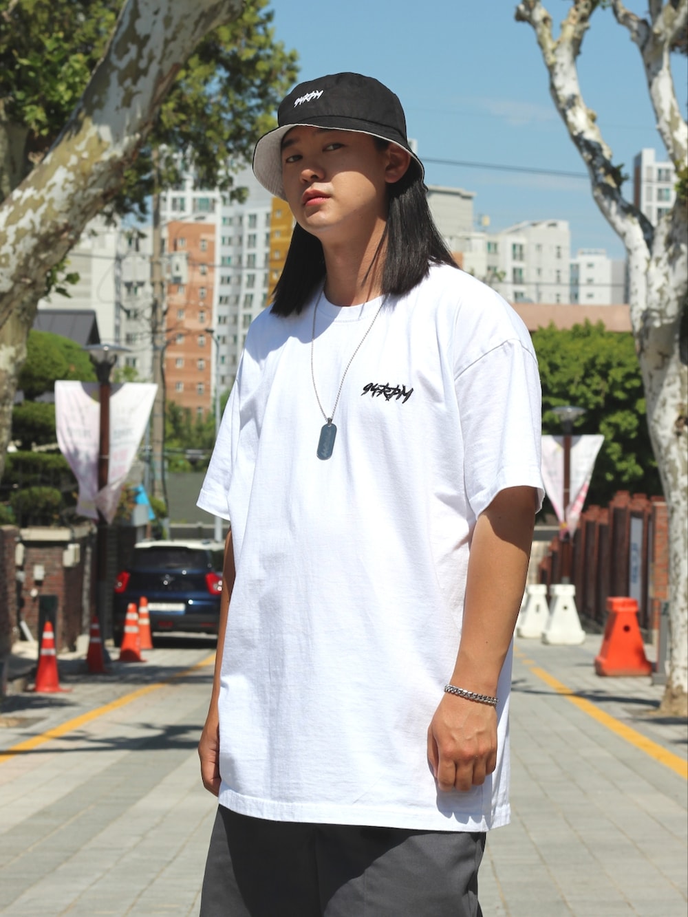 ホワイト系のTシャツ/カットソー、グレー系のデニムパンツ、ブラック系のスニーカーを着用したメンズの春コーディネートの4枚目の写真