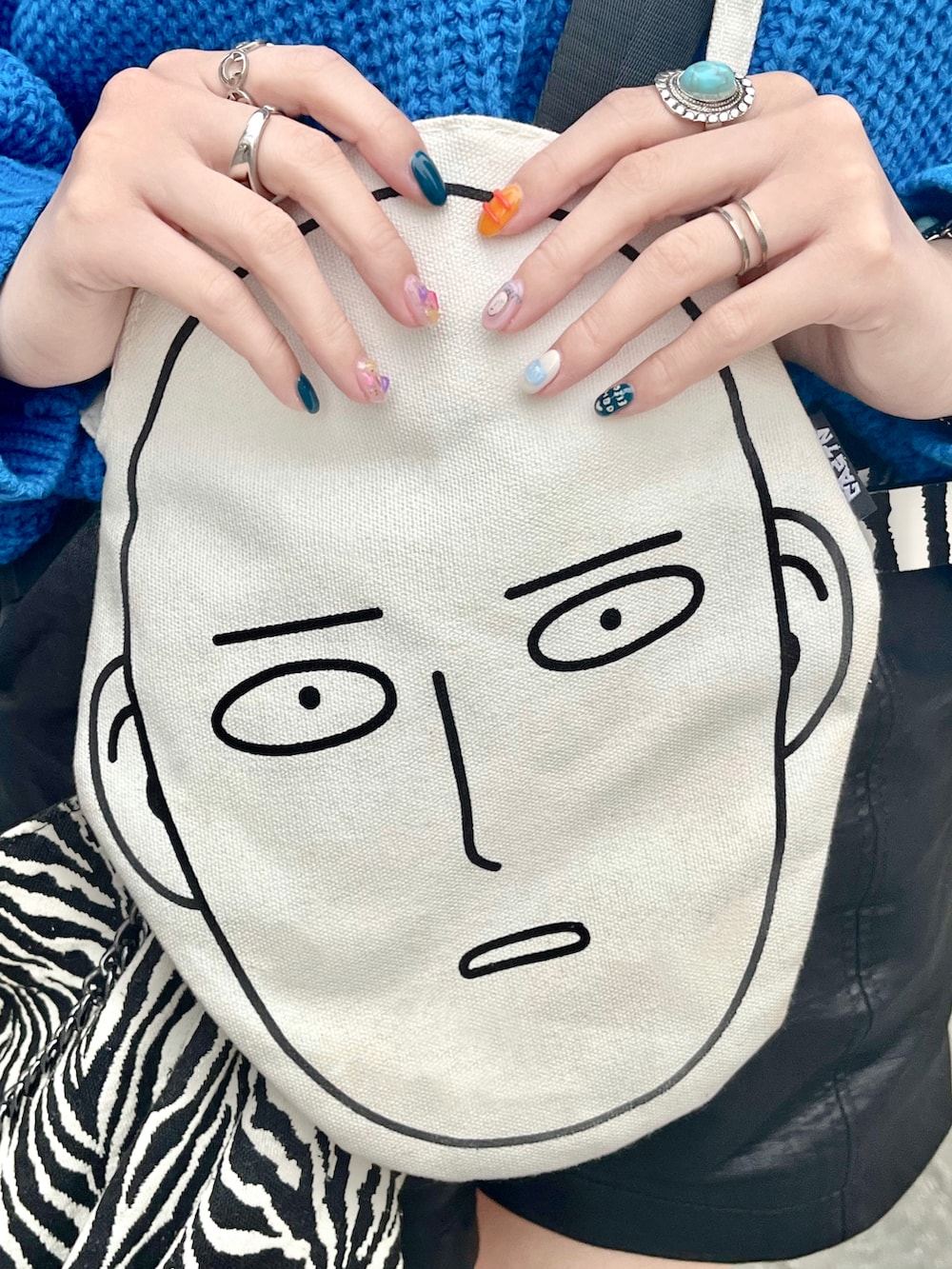 ブルー系のニット/セーター、ブラック系のカーゴパンツ、ブラック系のサンダルを着用したレディースの春コーディネートの3枚目の写真