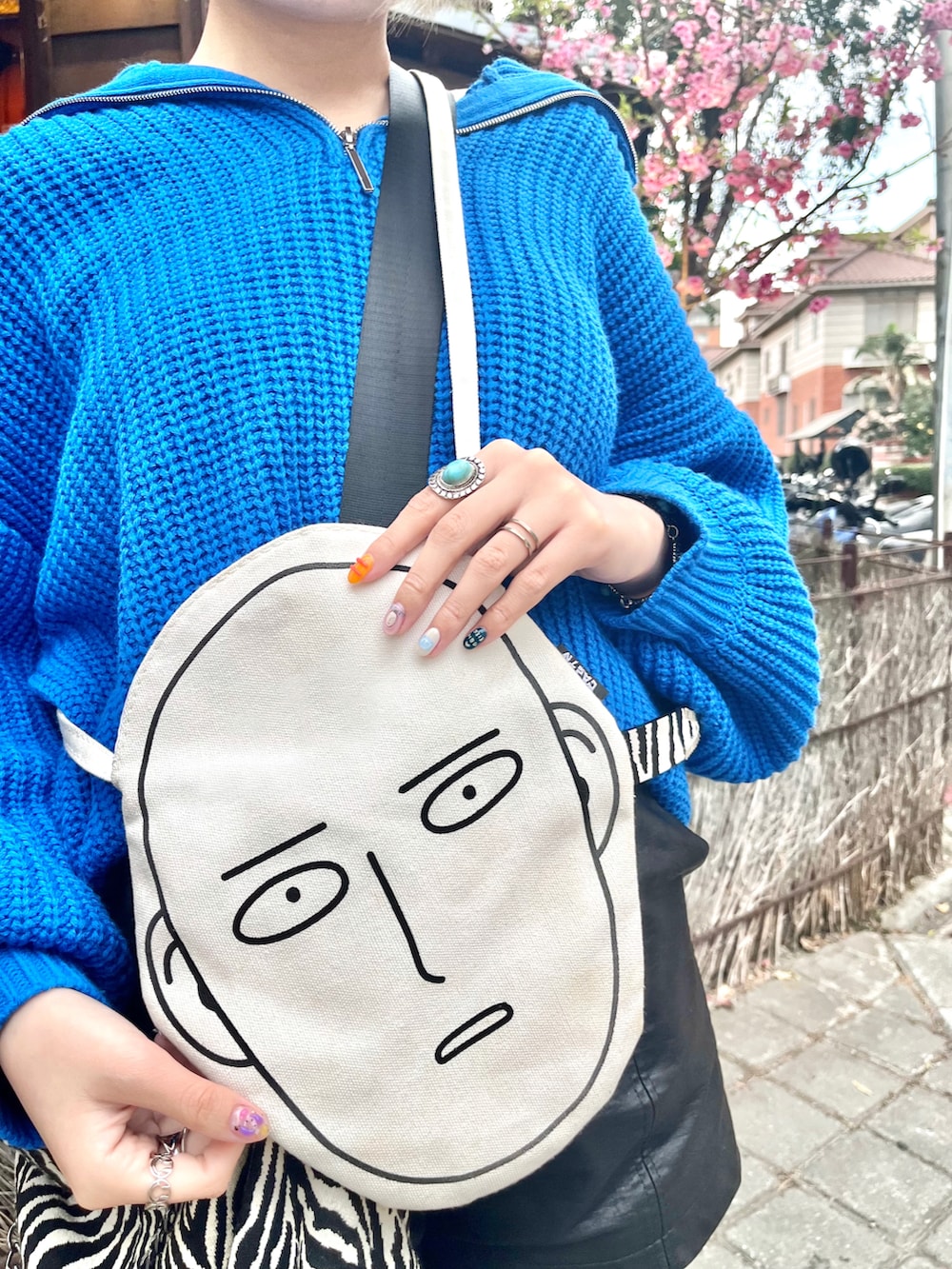 ブルー系のニット/セーター、ブラック系のカーゴパンツ、ブラック系のサンダルを着用したレディースの春コーディネートの2枚目の写真