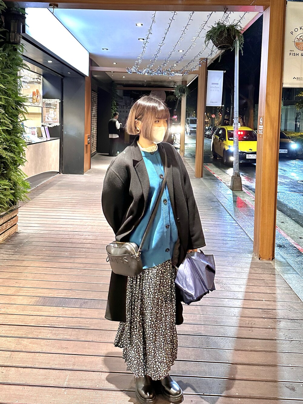 ブラック系のその他アウター、ブルー系のカーディガン/ボレロ、ブラック系のスカートを着用したレディースの冬コーディネートの2枚目の写真