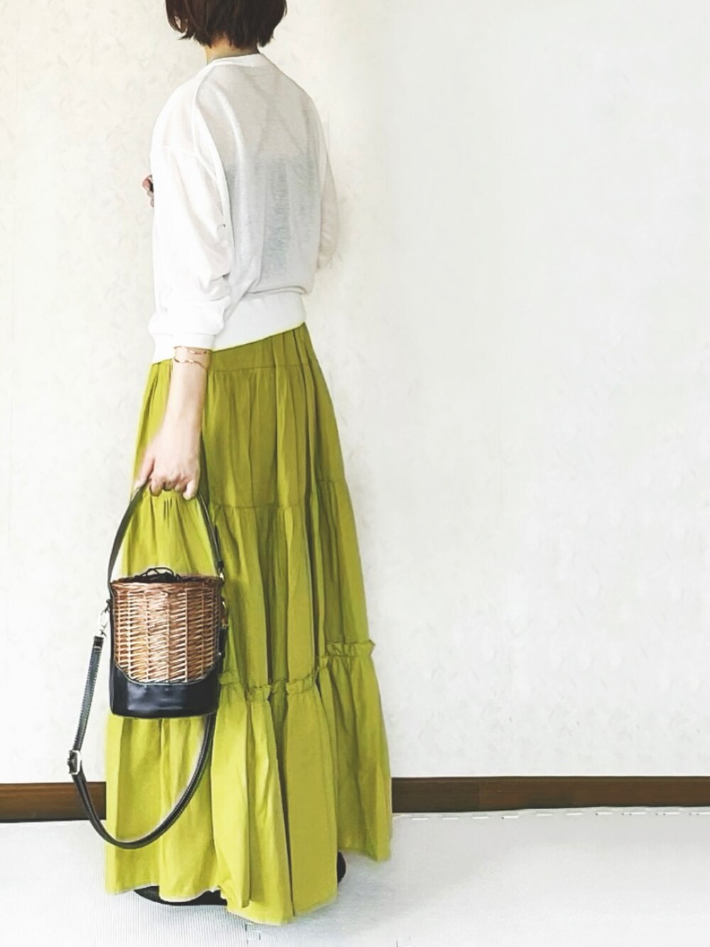 イエロー系のスカートを着用したレディースの春コーディネートの3枚目の写真