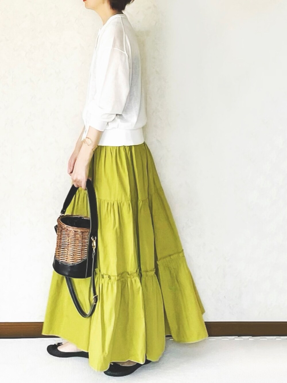 イエロー系のスカートを着用したレディースの春コーディネートの2枚目の写真