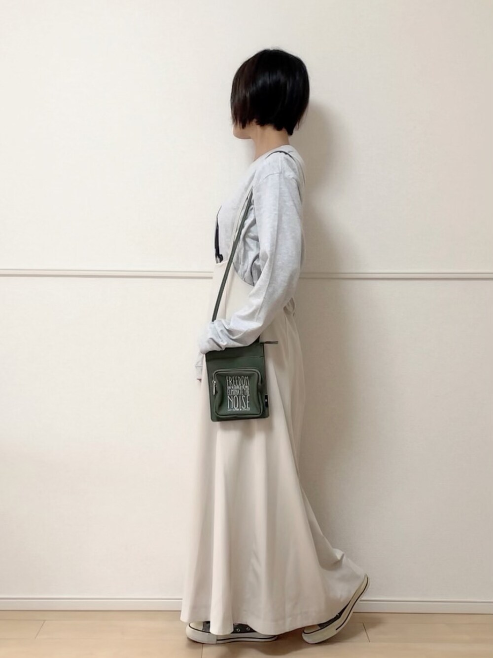 グレー系のTシャツ/カットソー、ホワイト系のスカート、グレー系のスニーカーを着用したレディースの秋コーディネートの2枚目の写真