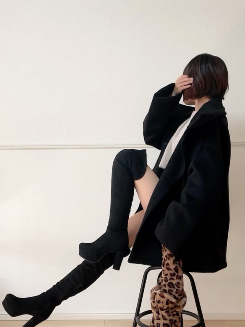 ブラック系のブーツ、ブラック系のその他アウター、ベージュ系のニット/セーターを着用したレディースの秋コーディネートの5枚目の写真