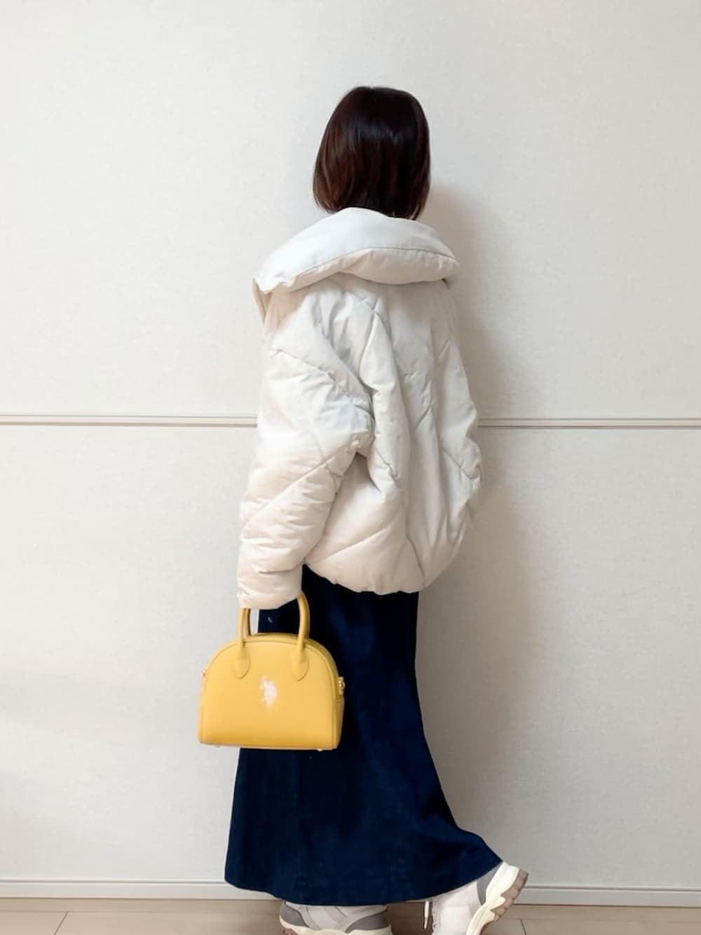 ホワイト系のダウンジャケット/コート、ホワイト系のその他トップス、ブルー系のジャンパースカートを着用したレディースの冬コーディネートの3枚目の写真