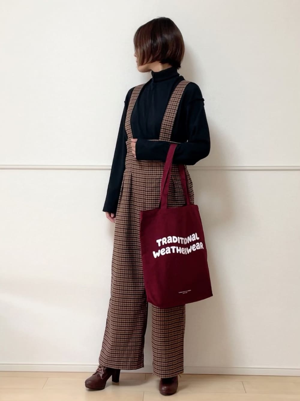 ブラック系のノーカラージャケット、ブラック系のTシャツ/カットソー、ブラウン系のサロペット/オーバーオールを着用したレディースの秋コーディネートの2枚目の写真