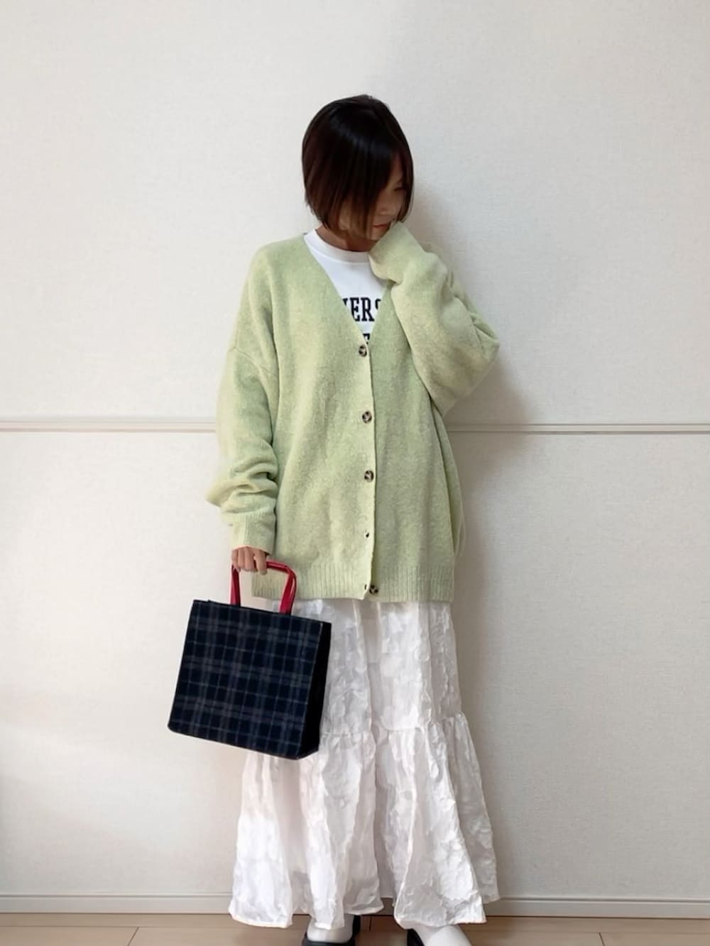グリーン系のカーディガン/ボレロ、ホワイト系のスウェット、ホワイト系のスカートを着用したレディースの冬コーディネートの2枚目の写真