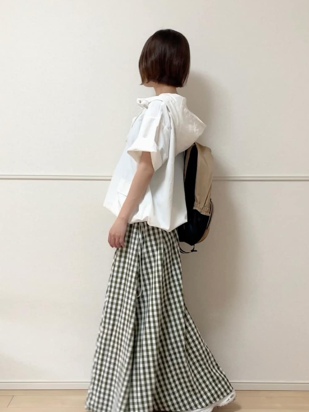 ホワイト系のパーカー、ブルー系のスカート、ホワイト系のスニーカーを着用したレディースの春コーディネートの2枚目の写真