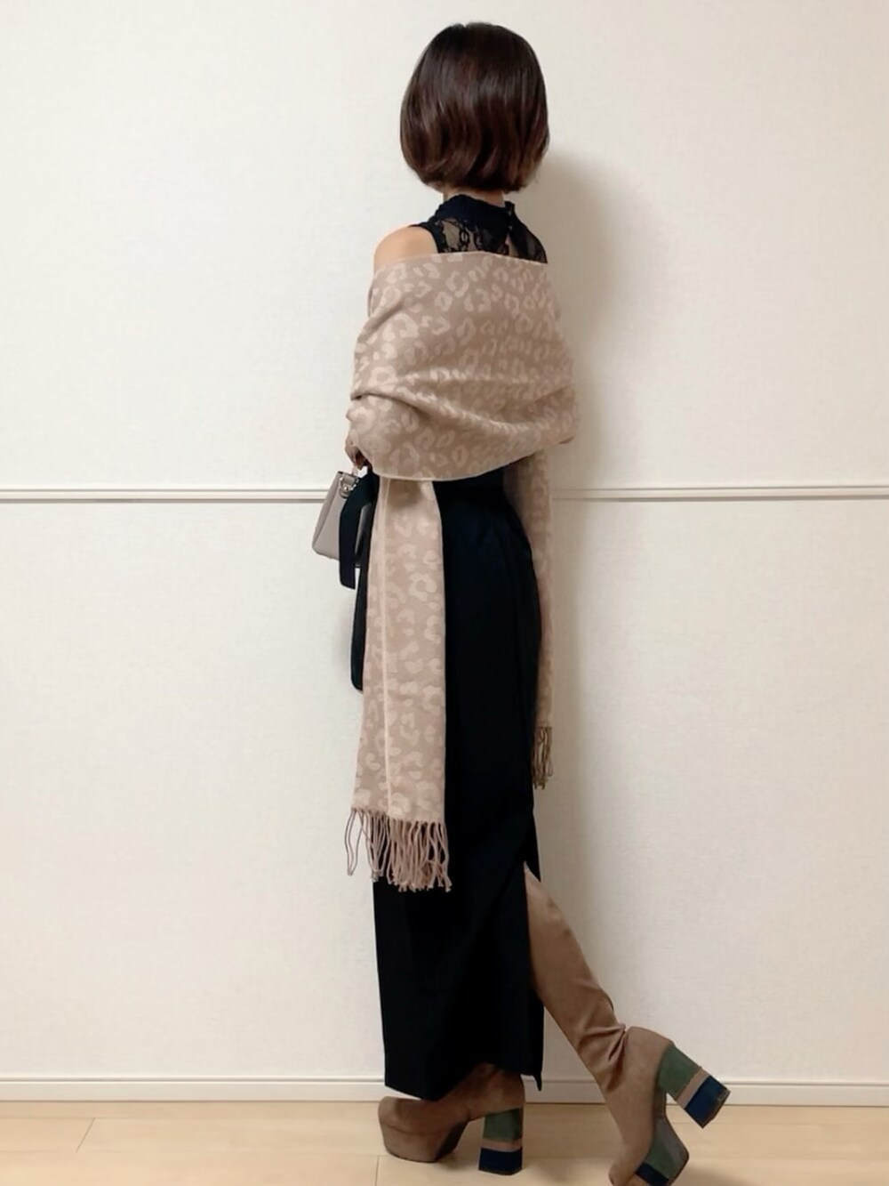 ブラック系のスカート、ブラック系のTシャツ/カットソー、ベージュ系のブーツを着用したレディースの秋コーディネートの2枚目の写真