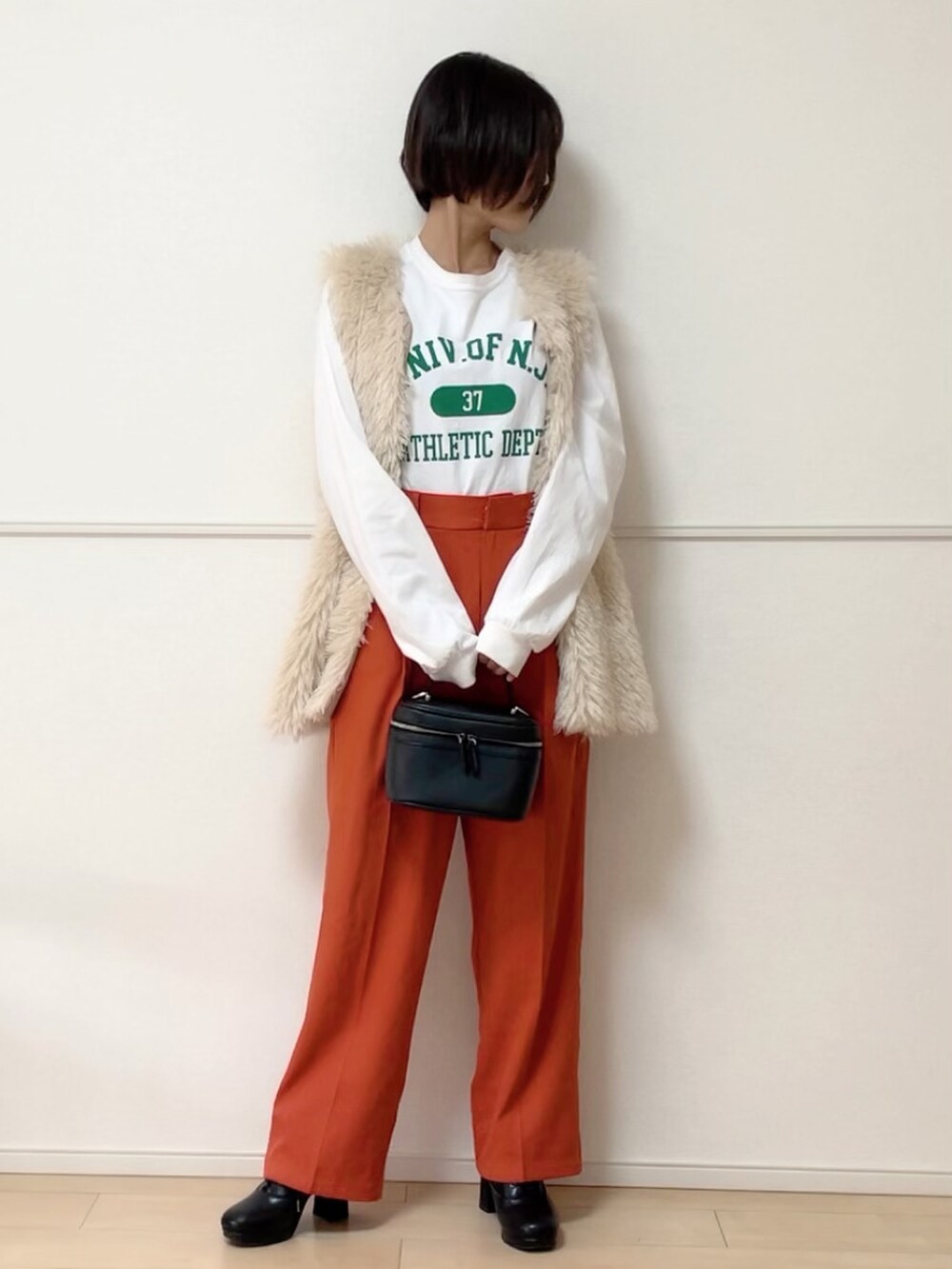 グレー系のカーディガン/ボレロ、ホワイト系のベスト、ホワイト系のTシャツ/カットソーを着用したレディースの秋コーディネートの2枚目の写真