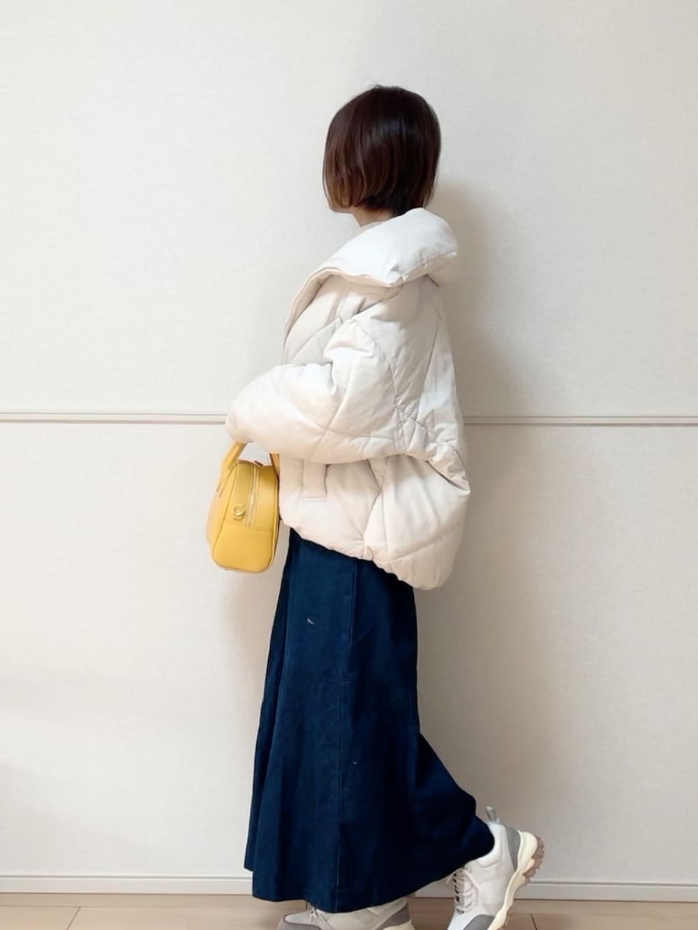 ホワイト系のダウンジャケット/コート、ホワイト系のその他トップス、ブルー系のジャンパースカートを着用したレディースの冬コーディネートの2枚目の写真