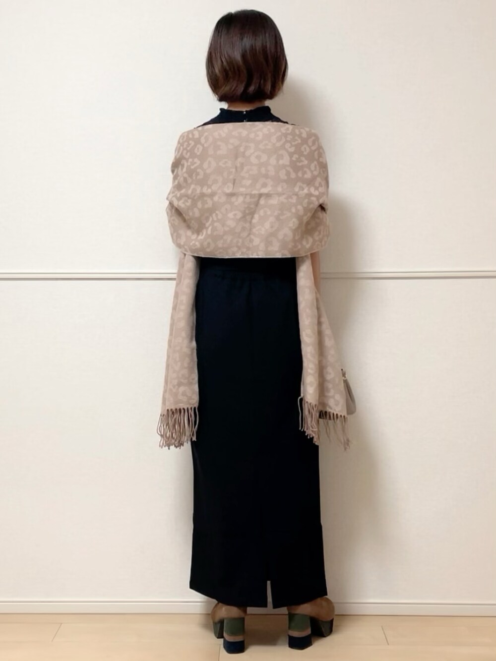 ブラック系のスカート、ブラック系のTシャツ/カットソー、ベージュ系のブーツを着用したレディースの秋コーディネートの3枚目の写真