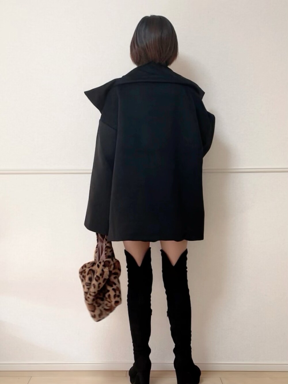 ブラック系のブーツ、ブラック系のその他アウター、ベージュ系のニット/セーターを着用したレディースの秋コーディネートの3枚目の写真