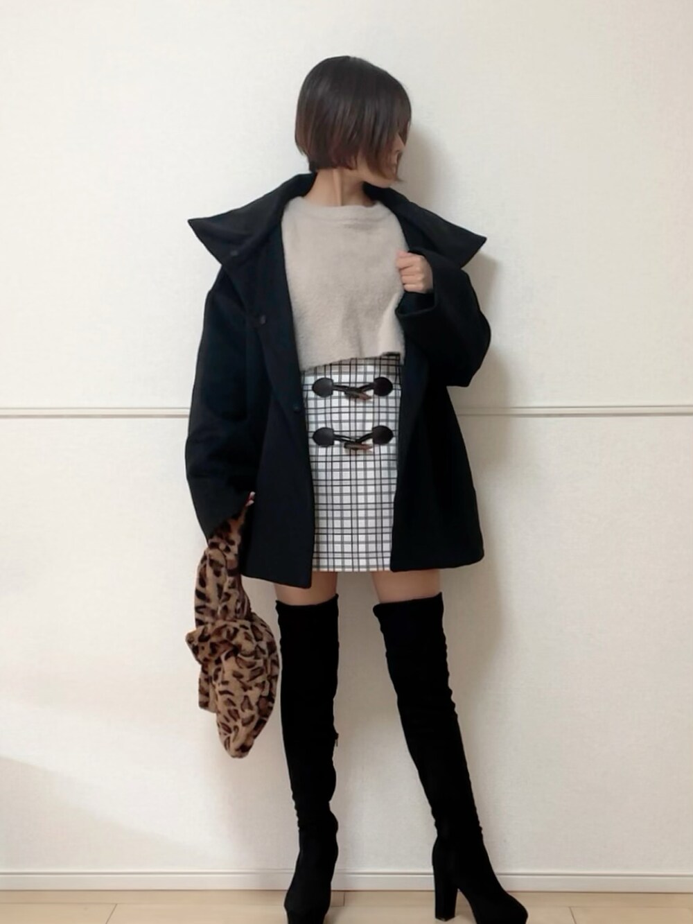 ブラック系のブーツ、ブラック系のその他アウター、ベージュ系のニット/セーターを着用したレディースの秋コーディネートの4枚目の写真