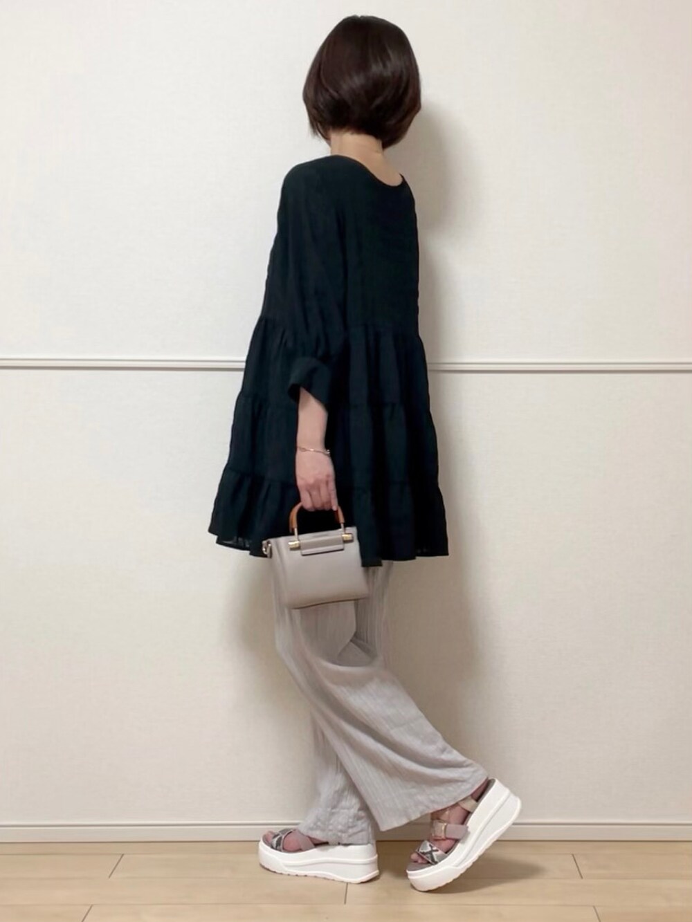 ブラック系のチュニック、グレー系のその他パンツ、その他のサンダルを着用したレディースの春コーディネートの2枚目の写真