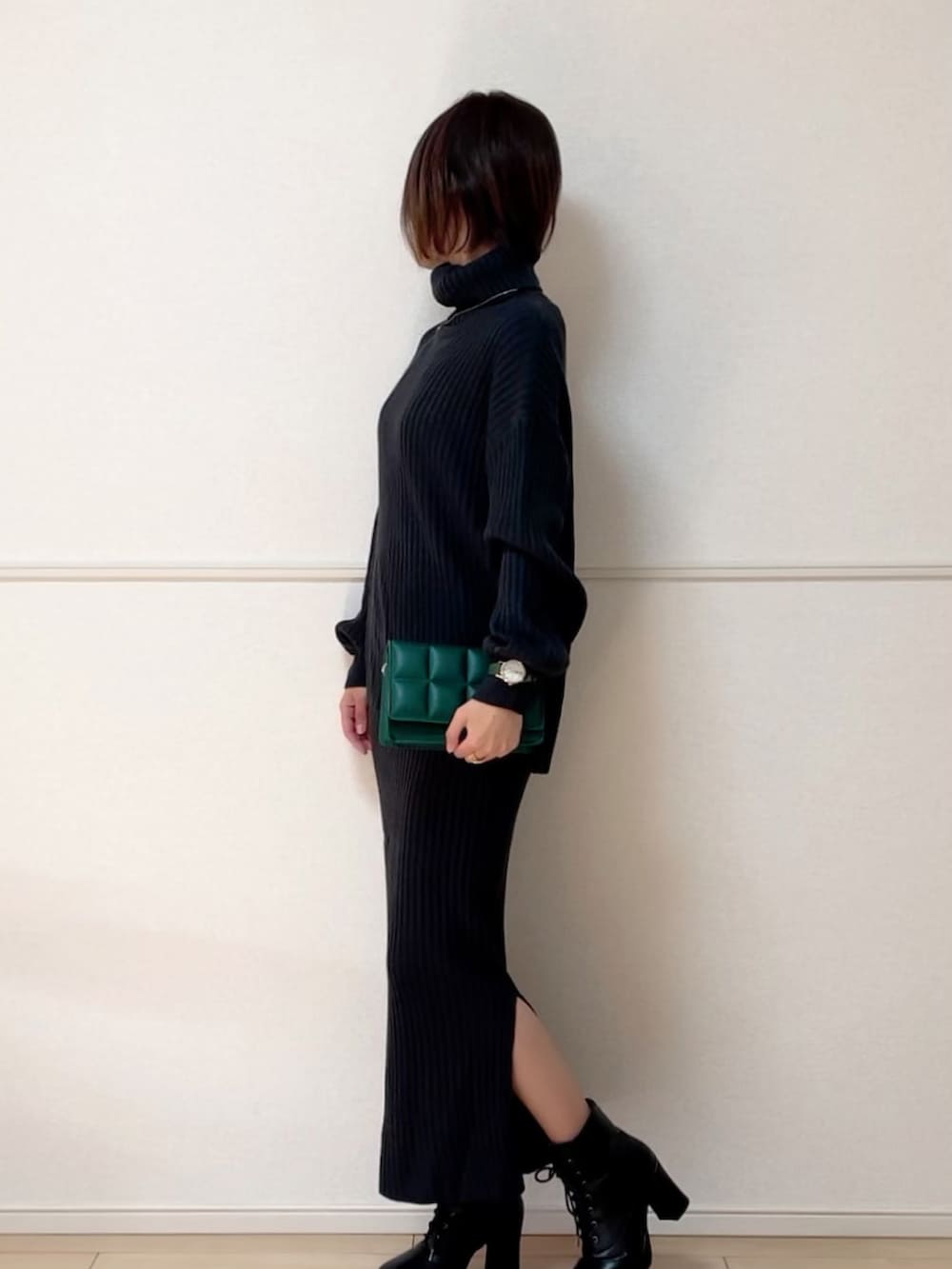 グレー系のワンピース、ブラック系のブーツ、グリーン系のアナログ腕時計を着用したレディースの冬コーディネートの2枚目の写真