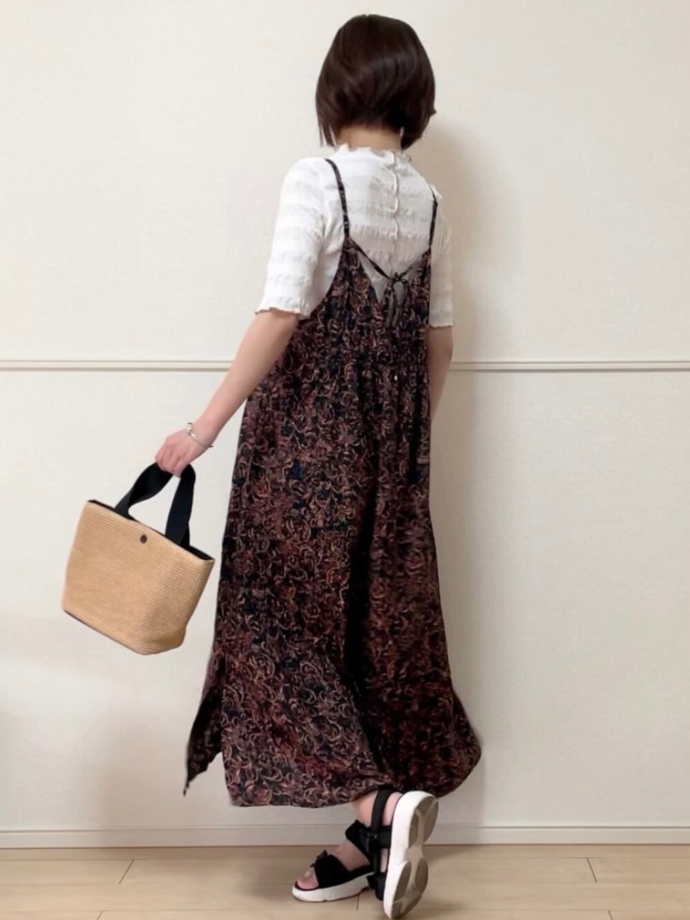 ブラック系のワンピース、ホワイト系のシャツ/ブラウス、ブラック系のサンダルを着用したレディースの春コーディネートの2枚目の写真