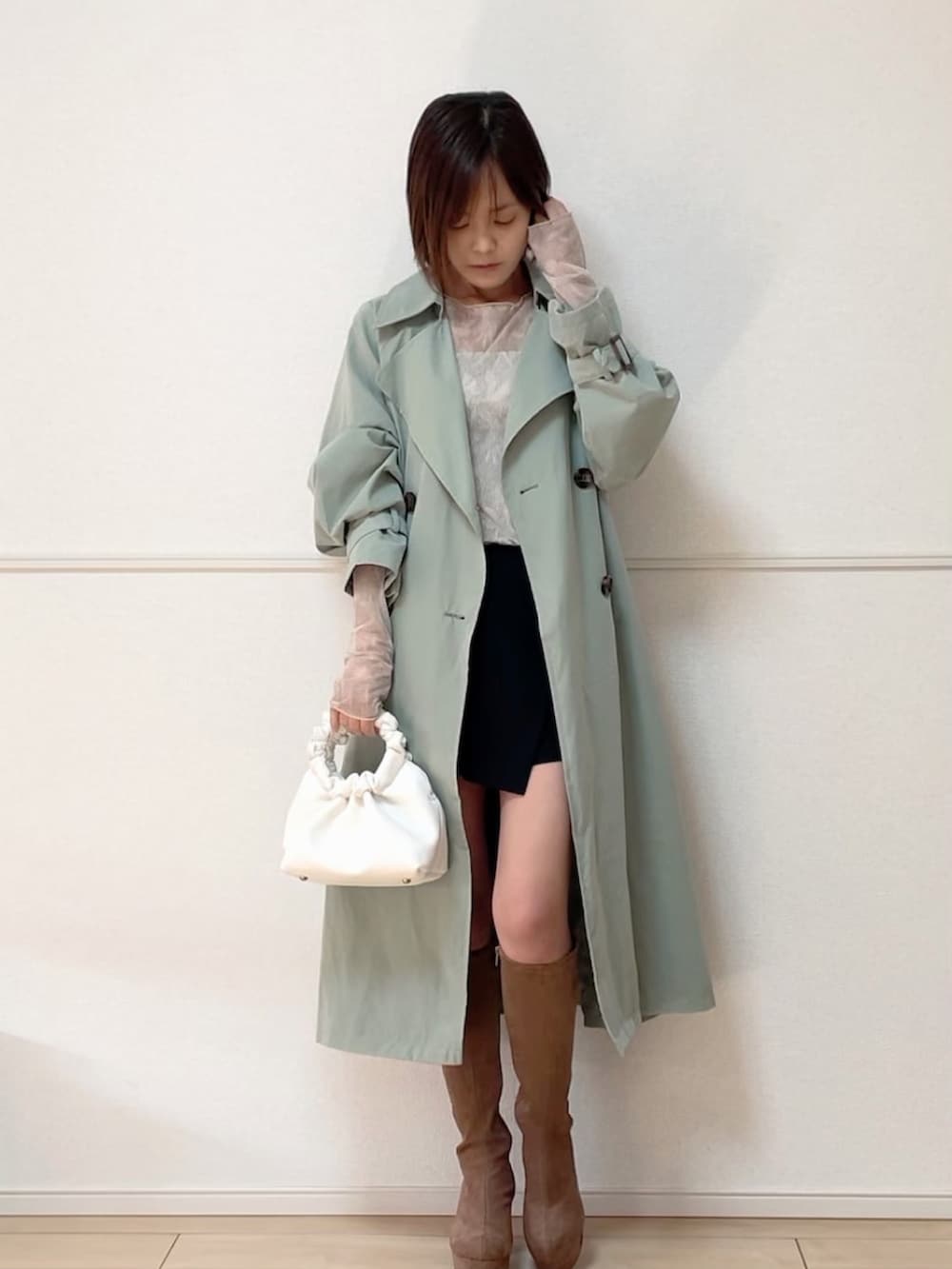 グリーン系のトレンチコート、グリーン系のTシャツ/カットソー、ホワイト系のキャミソールを着用したレディースの春コーディネートの2枚目の写真