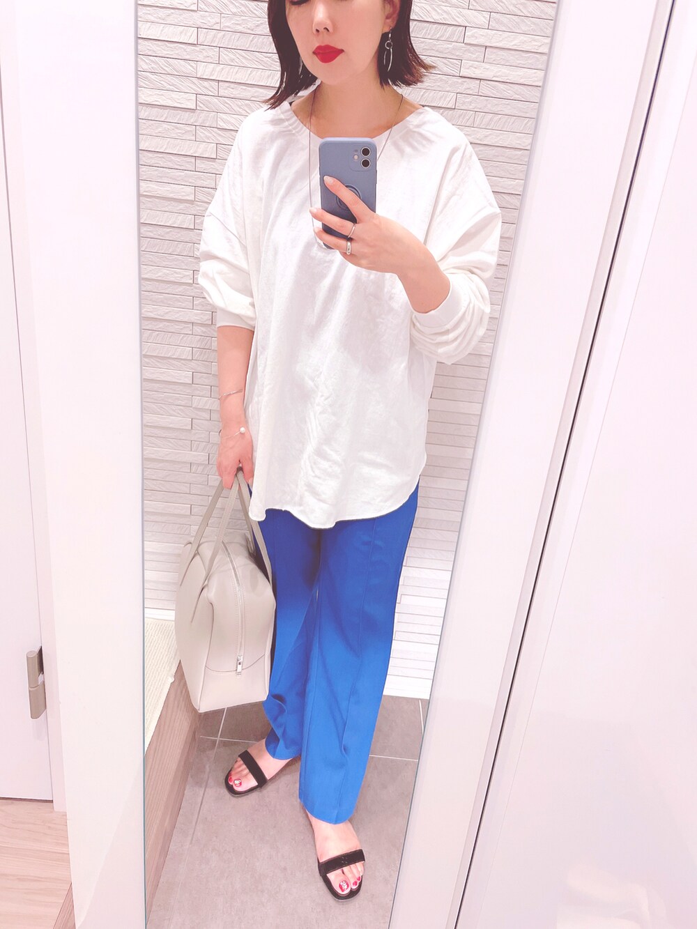 ホワイト系のTシャツ/カットソー、ブルー系のその他パンツ、ブラック系のサンダルを着用したレディースの春コーディネートの2枚目の写真