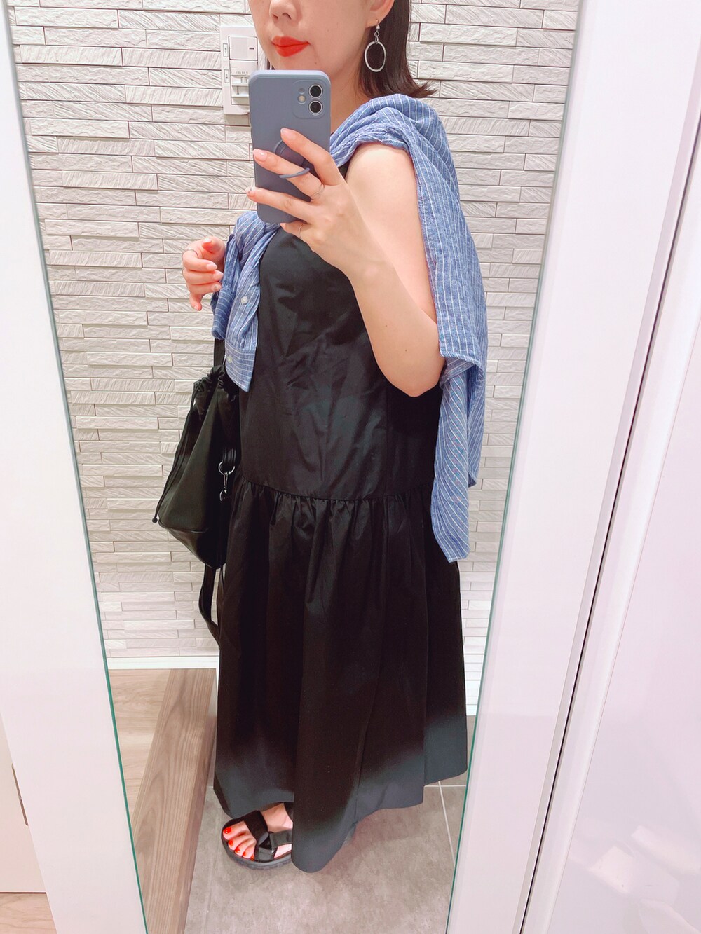 ブラック系のワンピース、ブルー系のシャツ/ブラウス、ブラック系のサンダルを着用したレディースの夏コーディネートの3枚目の写真