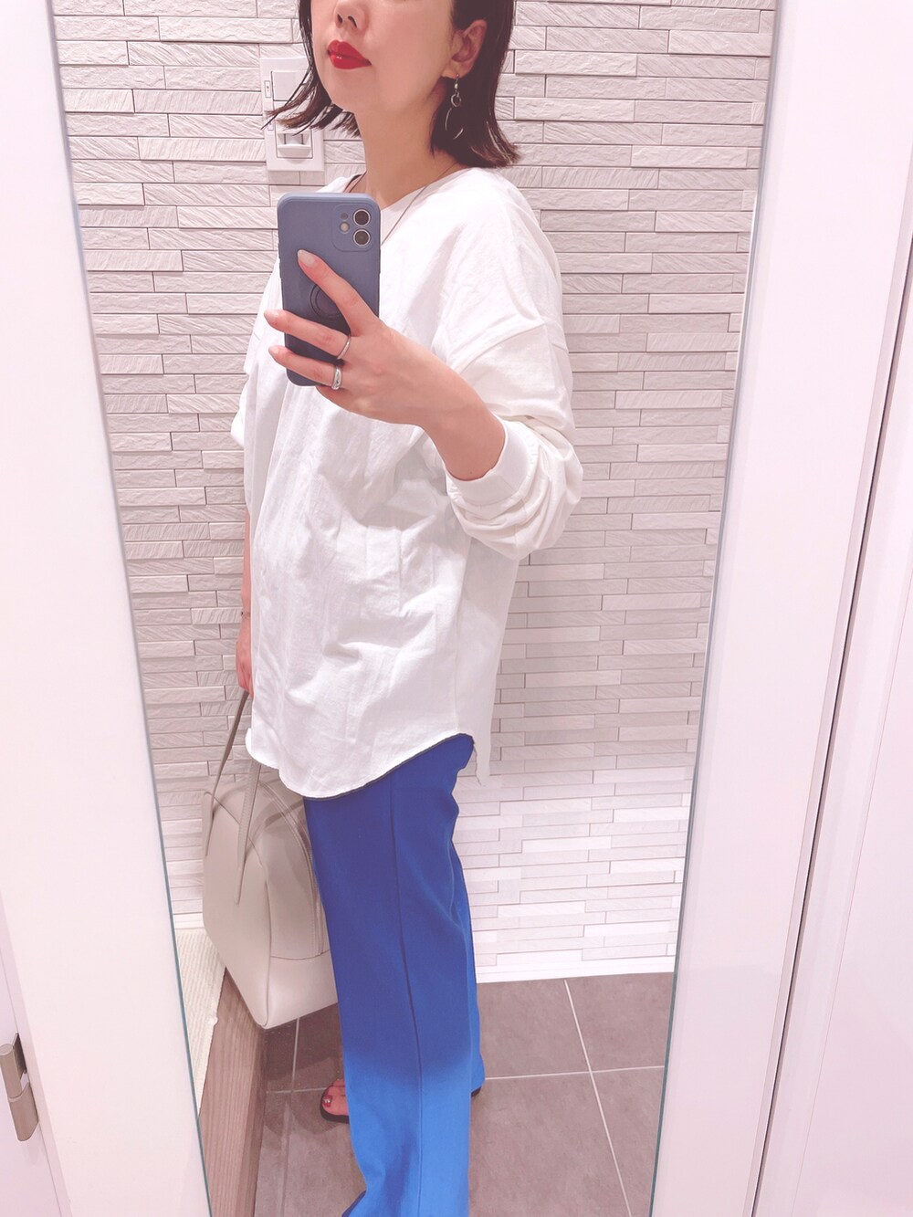 ホワイト系のTシャツ/カットソー、ブルー系のその他パンツ、ブラック系のサンダルを着用したレディースの春コーディネートの3枚目の写真