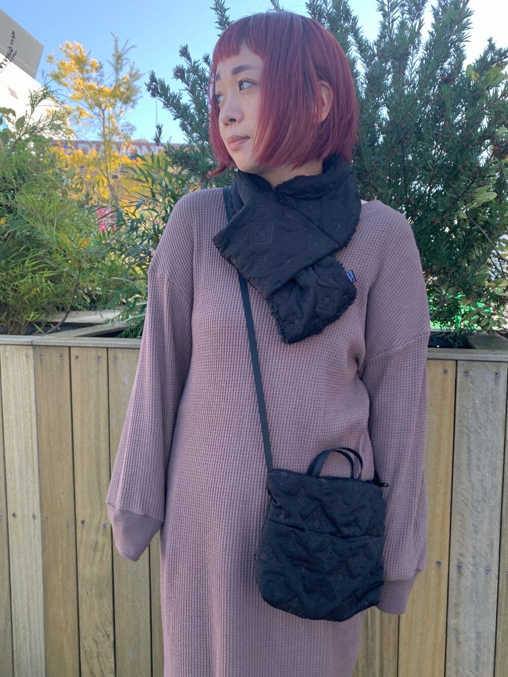 ブラック系のショルダーバッグ、ベージュ系のスニーカー、ブラック系のマフラーを着用したレディースの秋コーディネートの4枚目の写真