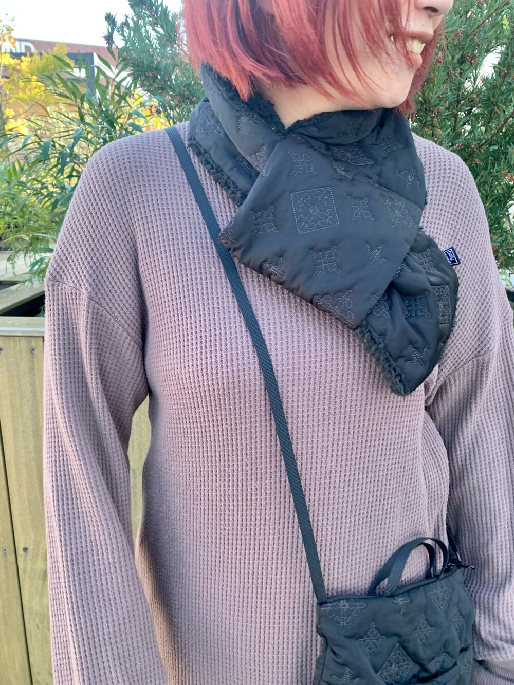 ブラック系のショルダーバッグ、ベージュ系のスニーカー、ブラック系のマフラーを着用したレディースの秋コーディネートの3枚目の写真