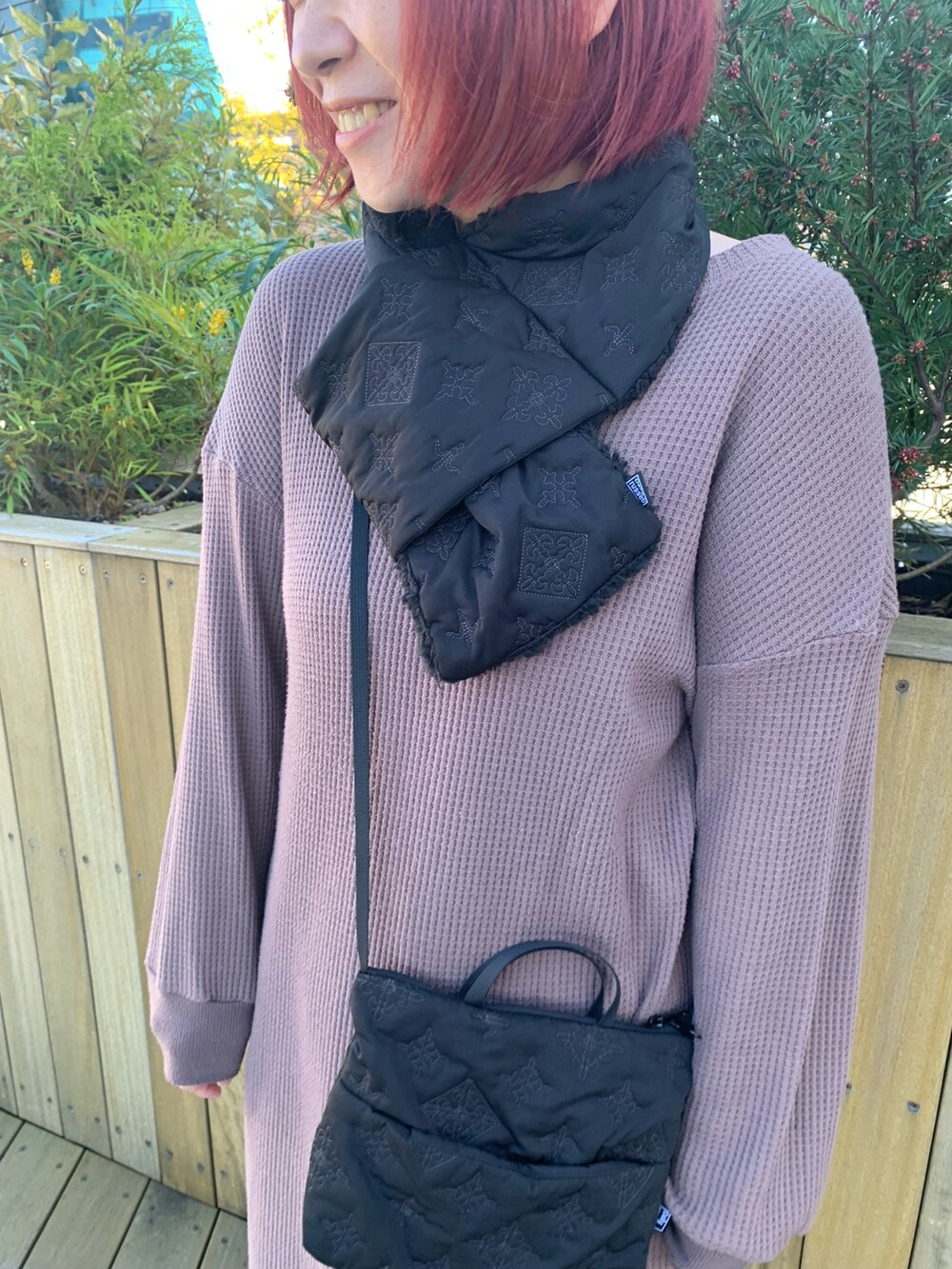 ブラック系のショルダーバッグ、ベージュ系のスニーカー、ブラック系のマフラーを着用したレディースの秋コーディネートの2枚目の写真