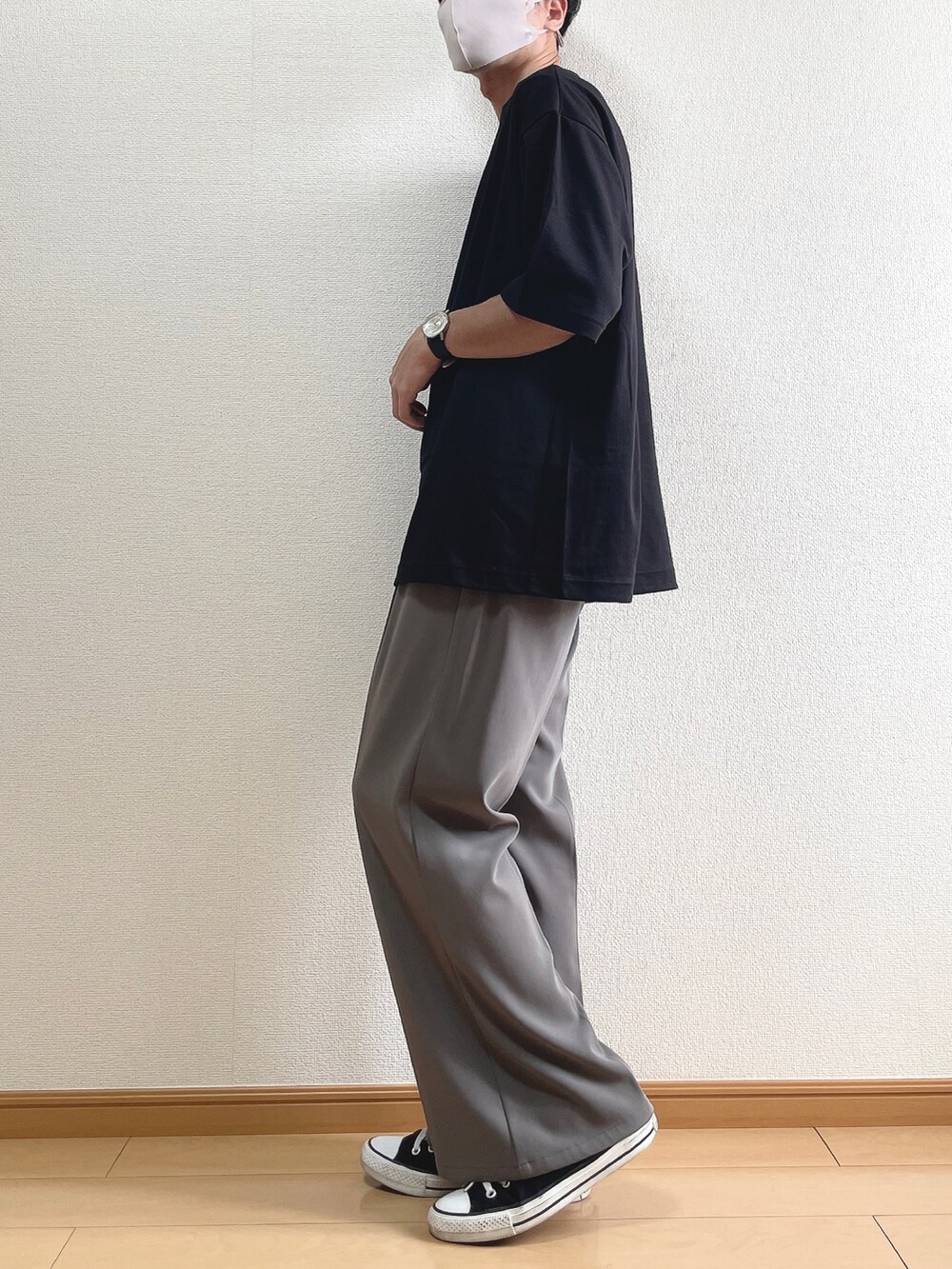 ブラック系のTシャツ/カットソー、ブラウン系のスラックス、ブラック系のスニーカーを着用したメンズの夏コーディネートの3枚目の写真