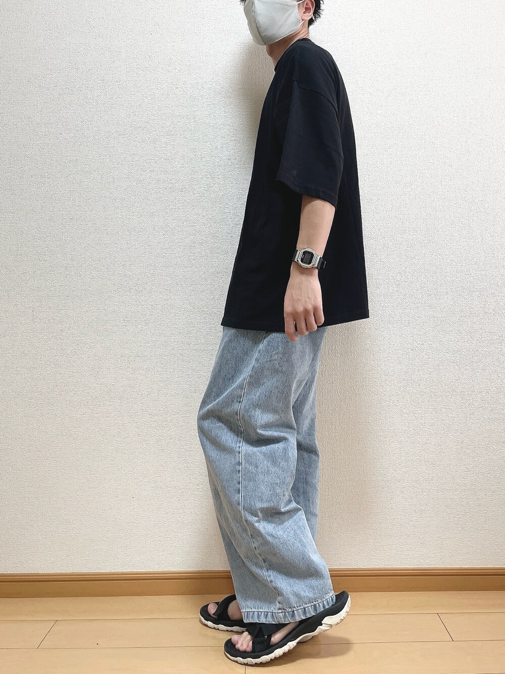 ブラック系のTシャツ/カットソー、ブルー系のデニムパンツ、ブラック系のサンダルを着用したメンズの夏コーディネートの3枚目の写真