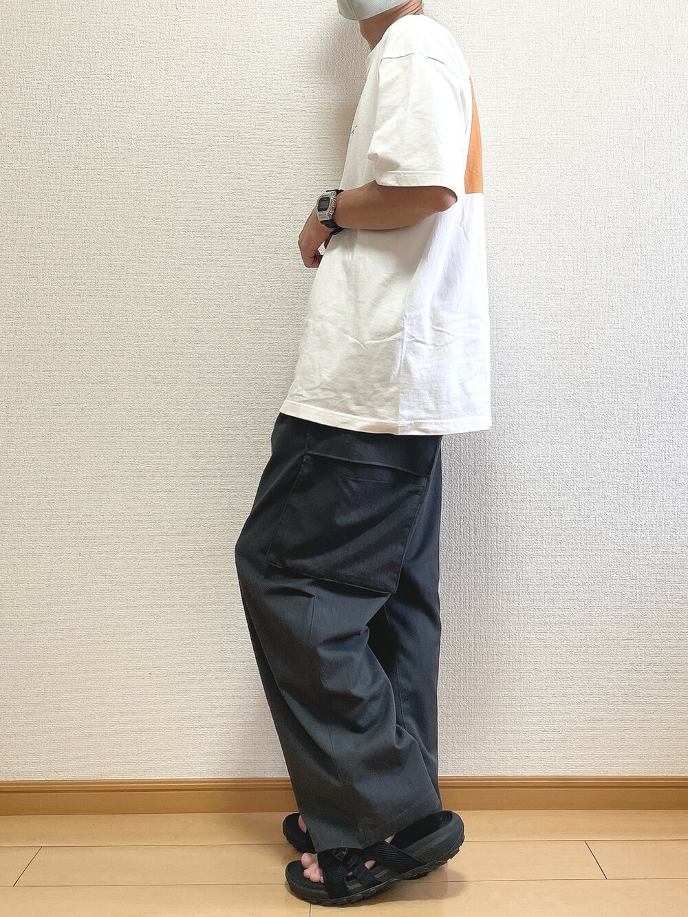 ホワイト系のTシャツ/カットソー、グレー系のカーゴパンツ、ブラック系のサンダルを着用したメンズの夏コーディネートの3枚目の写真