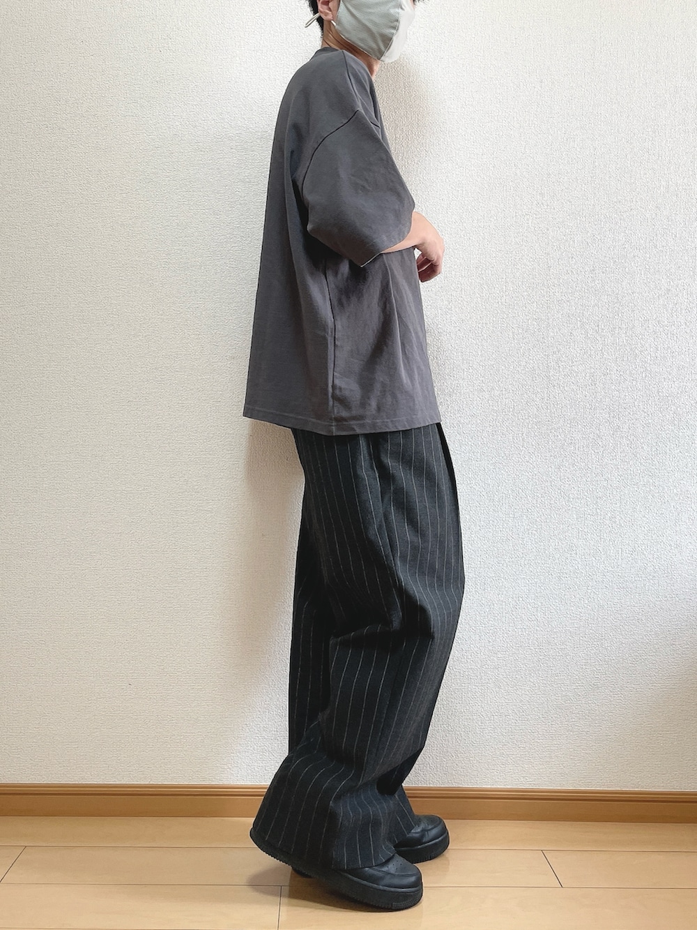 グレー系のTシャツ/カットソー、ブラック系のパンツ、ブラック系のスニーカーを着用したメンズの秋コーディネートの3枚目の写真