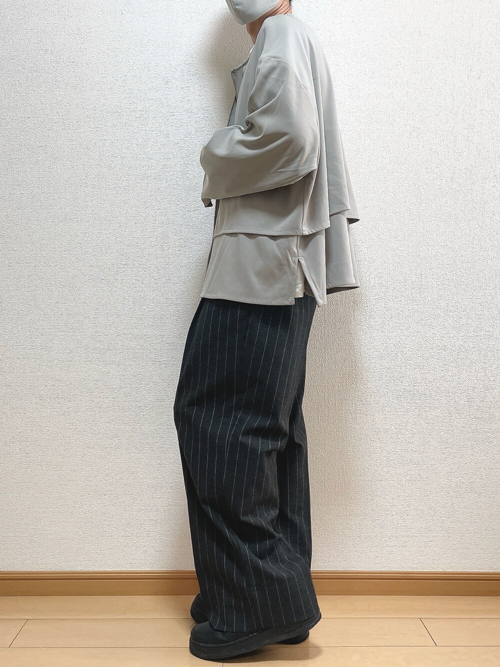 グレー系のブルゾン、ホワイト系のTシャツ/カットソー、ブラック系のパンツを着用したメンズの秋コーディネートの3枚目の写真