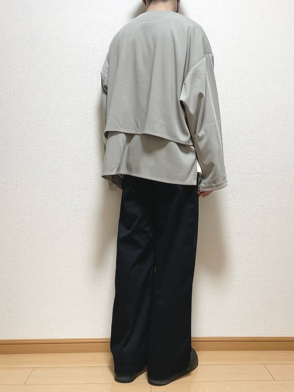 グレー系のブルゾン、ホワイト系のTシャツ/カットソー、ブラック系のスラックスを着用したメンズの春コーディネートの4枚目の写真