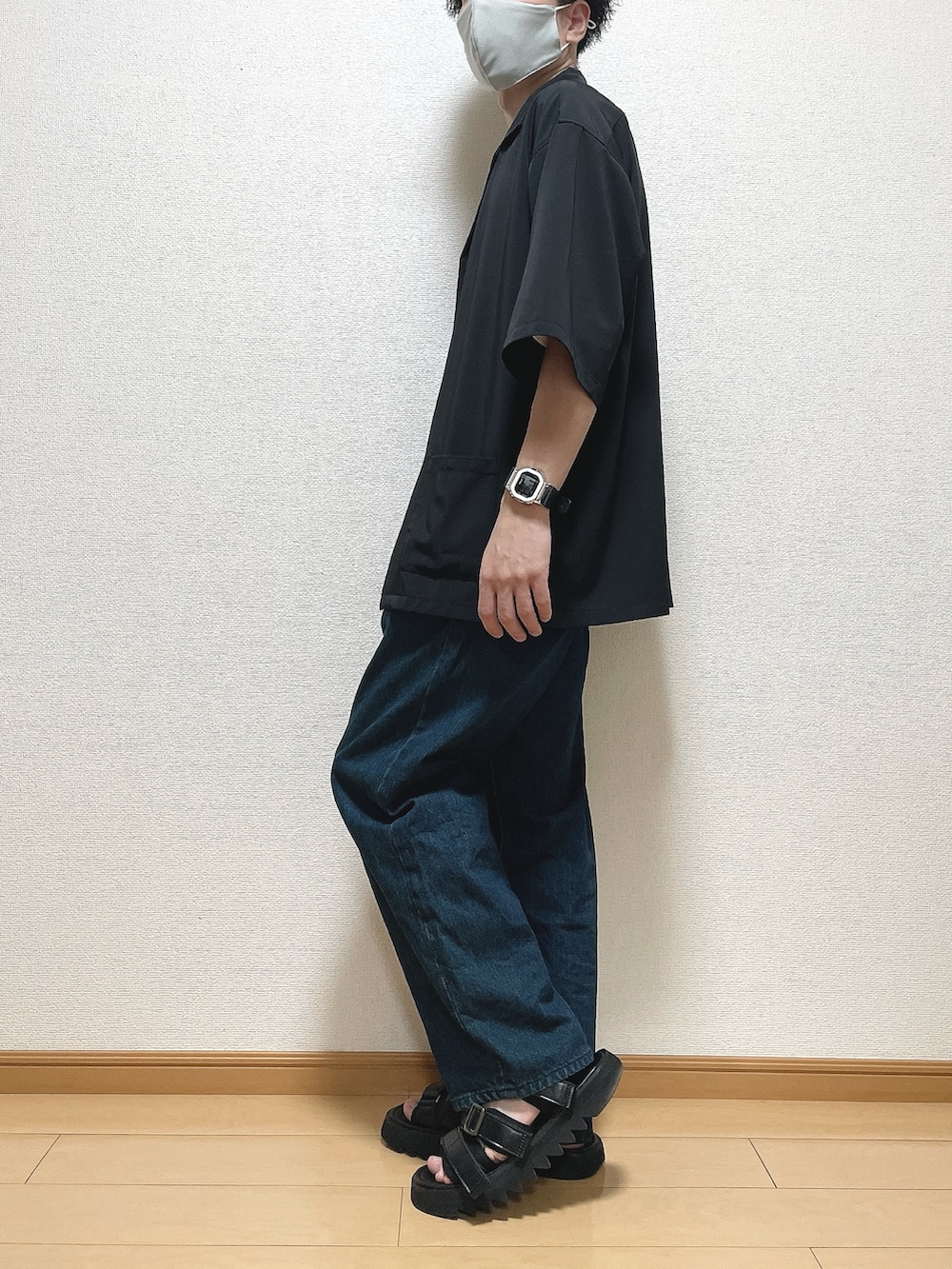 ホワイト系のTシャツ/カットソー、ブルー系のデニムパンツ、ブラック系のサンダルを着用したメンズの夏コーディネートの3枚目の写真